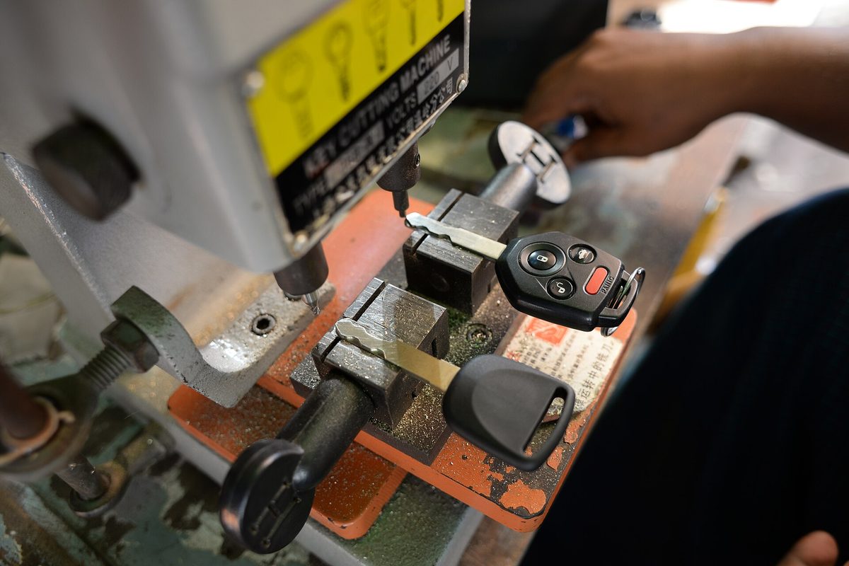 Duplicadora manual copiando una llave de auto: la original y la nueva sujetas lado a lado